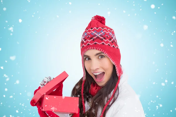 Excited brunette opening christmas gift — Stock Photo, Image