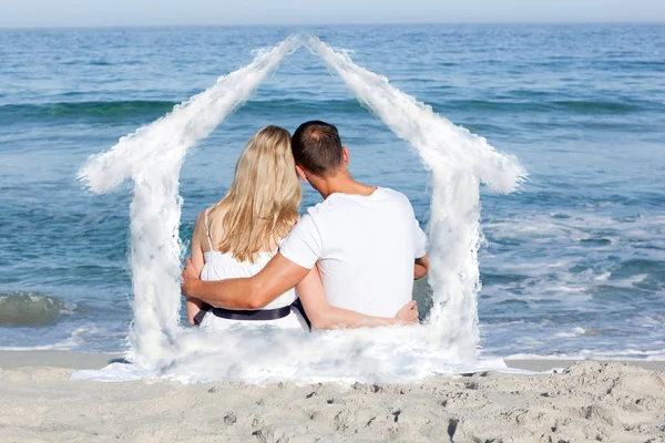 Casal afetuoso sentado na areia — Fotografia de Stock