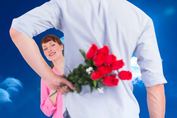 Homem segurando rosas atrás dele — Fotografia de Stock