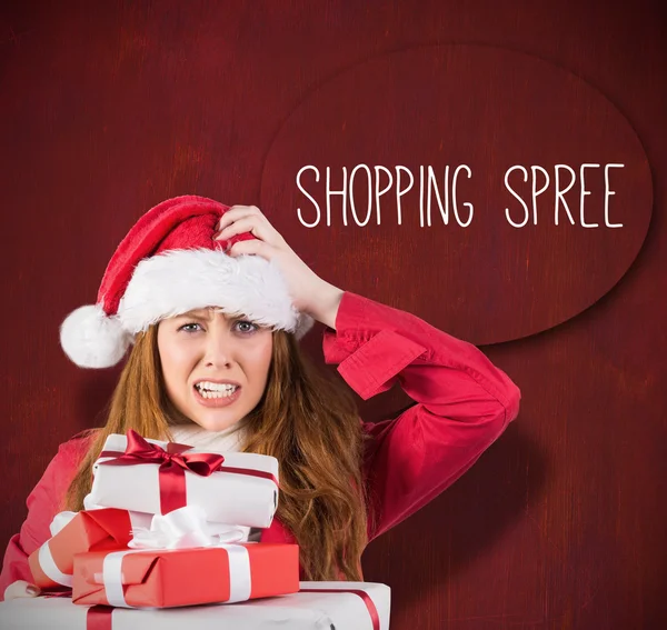 Festive stressed redhead holding gifts — Stock Photo, Image