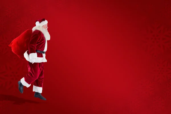 Santa claus carrying sack — Stock Photo, Image