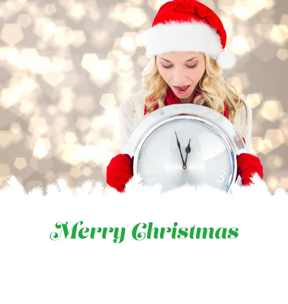 Composite image of happy festive blonde with clock — Stock Photo, Image