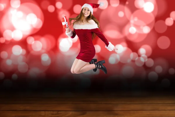 Festive redhead jumping with gift — Stock Photo, Image