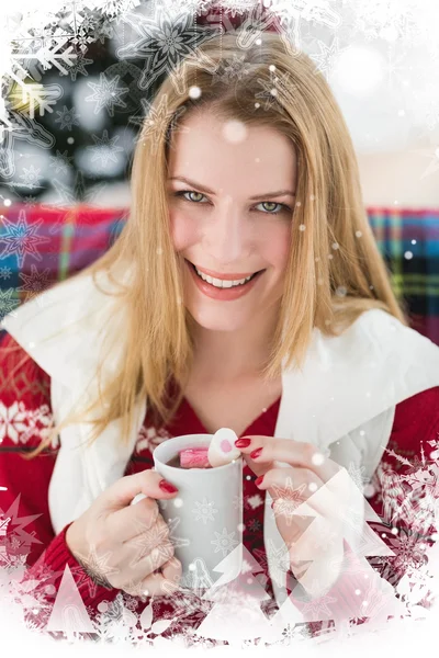 Улыбающаяся блондинка в зимней одежде держит кружку — стоковое фото