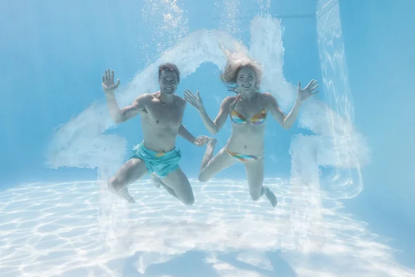 Cute couple smiling at camera underwater — Stock Photo, Image