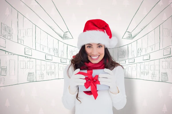 Bruna festiva in cappello di Babbo Natale in possesso di regalo — Foto Stock