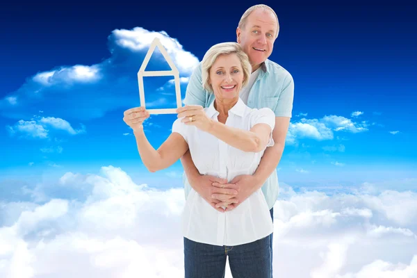 Happy older couple holding house shape — Stockfoto