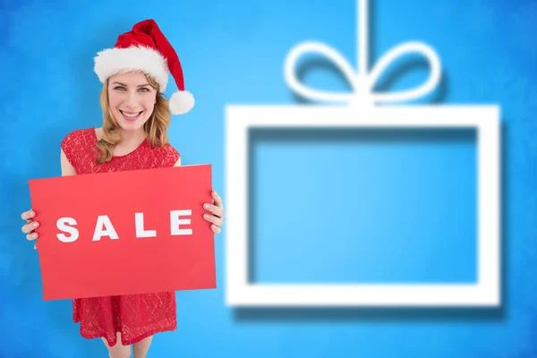 Vackra blonda i santa hatt håller en röd försäljning — Stockfoto