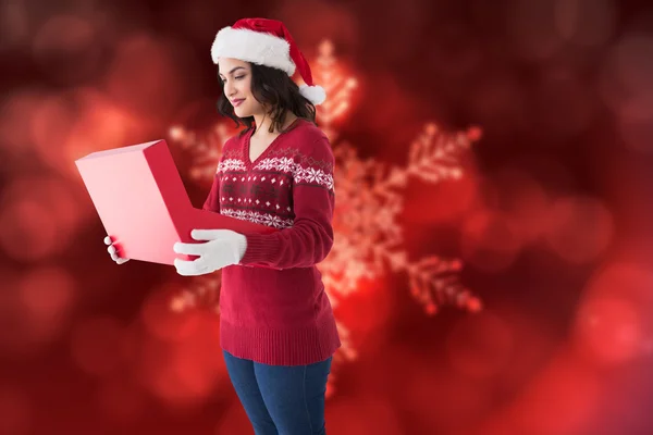 Festive brunette in winter clothes opening gift — Stock Photo, Image