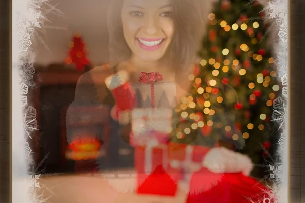 Pretty girl in santa outfit holding gift — Stock Photo, Image