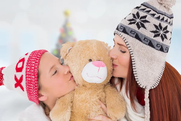 Mother and daughter kissing teddy — Stock Photo, Image