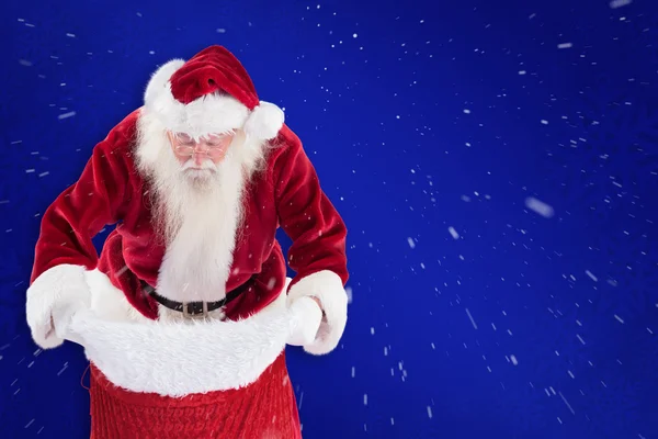 Weihnachtsmann schaut in seine Tasche — Stockfoto