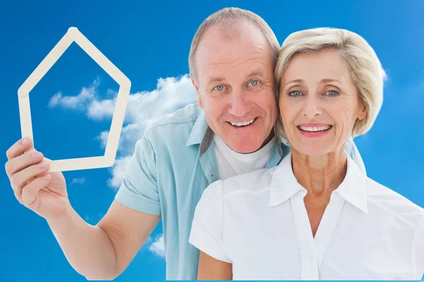 Feliz casal mais velho segurando a forma da casa — Fotografia de Stock