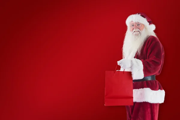 Santa draagt rode geschenk tas — Stockfoto