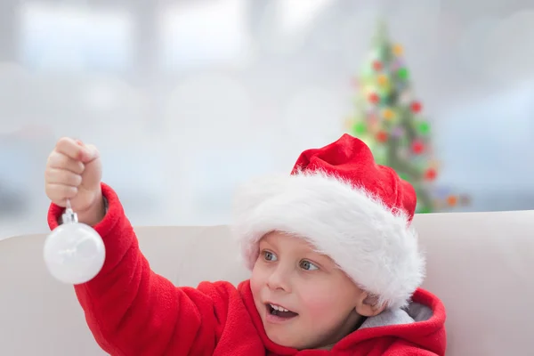 Zusammengesetzte Bild von niedlichen Jungen mit Christbaumkugel — Stockfoto