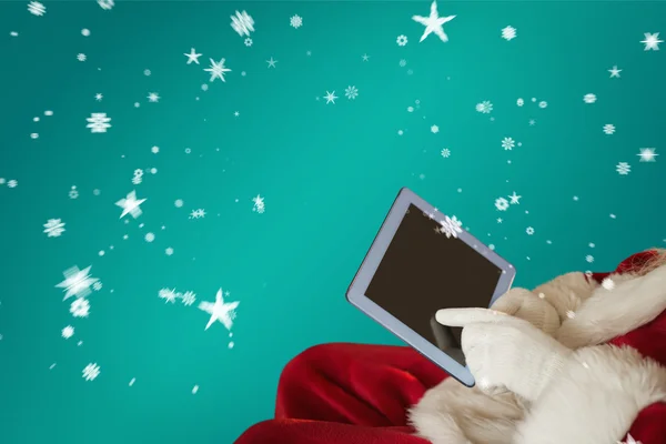 圣诞老人在扶手椅上使用平板电脑 — 图库照片