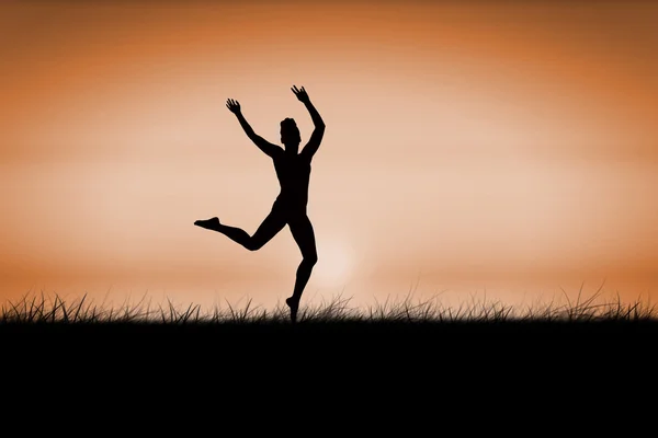 Brunette jumping against sunrise — Stock Photo, Image