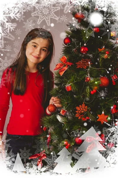 Menina sorrindo para a câmera ao lado da árvore de natal — Fotografia de Stock