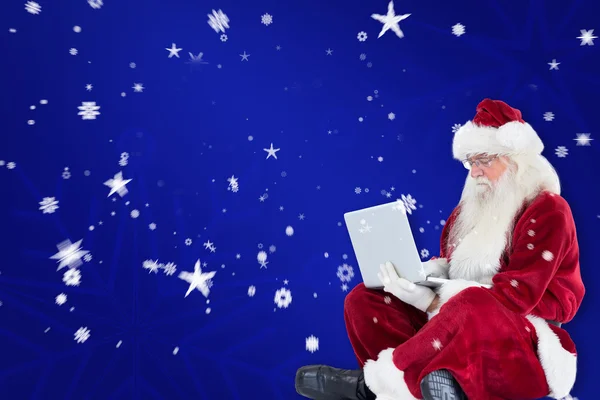 Papai Noel senta e usa laptop — Fotografia de Stock