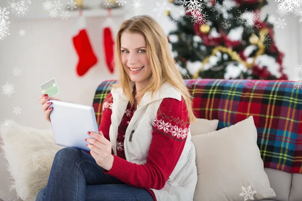 Cute blondynka siedzi na kanapie, trzymając karty kredytowej — Zdjęcie stockowe