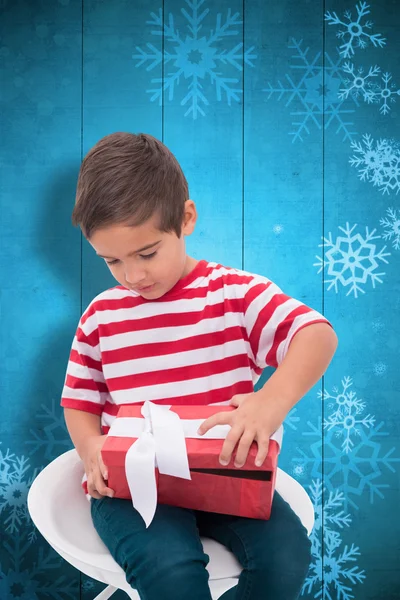 Прикольный образ милого маленького мальчика, открывающего подарок — стоковое фото