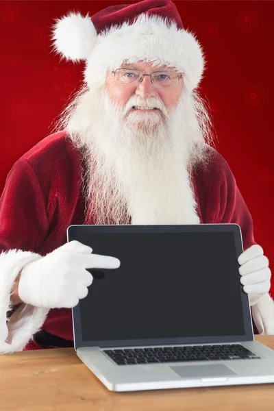 Glücklicher Weihnachtsmann zeigt Laptop — Stockfoto