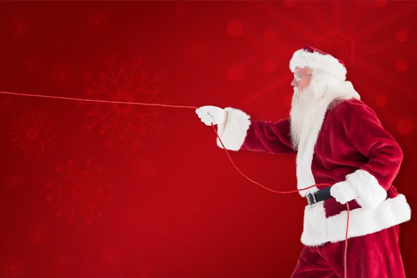 Santa pulls something with rope — Stock Photo, Image