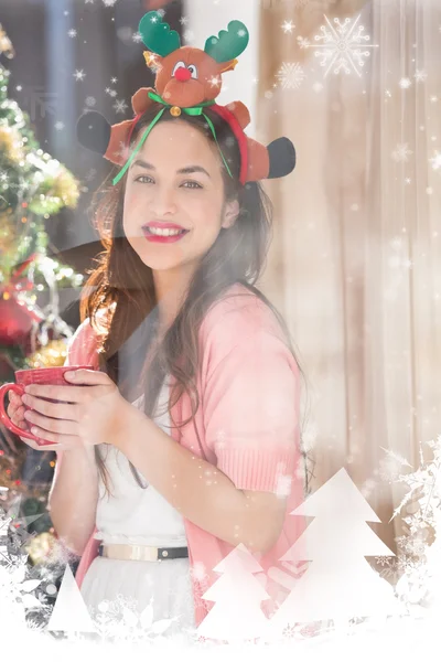 Brünette mit Weihnachtsmütze und Tasse — Stockfoto