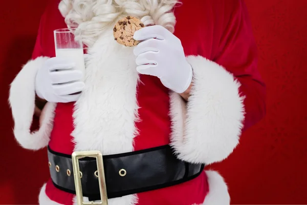 Zusammengesetztes Bild des Weihnachtsmannes mit Keksen und einem Glas Milch — Stockfoto