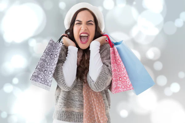 Composite image of excited brunette holding shopping bags — Stock Photo, Image