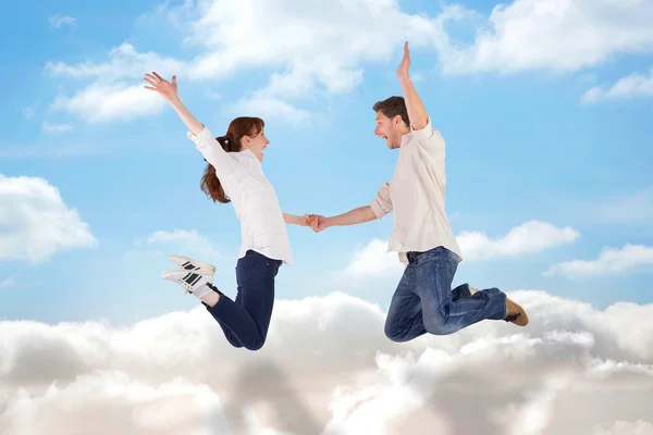 Paar springt und hält Händchen — Stockfoto
