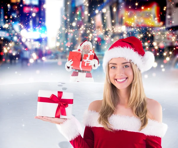 Pretty santa girl holding gift — Stock Photo, Image