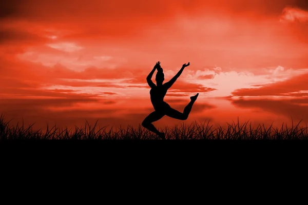 Brunette jumping against red sky — Stock Photo, Image