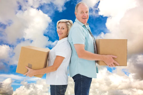 Divertente coppia più anziana che tiene scatole in movimento — Foto Stock