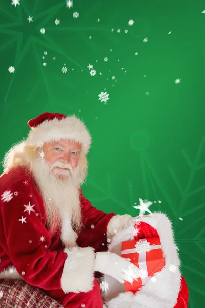 Vater Weihnachten nimmt rotes Geschenk — Stockfoto