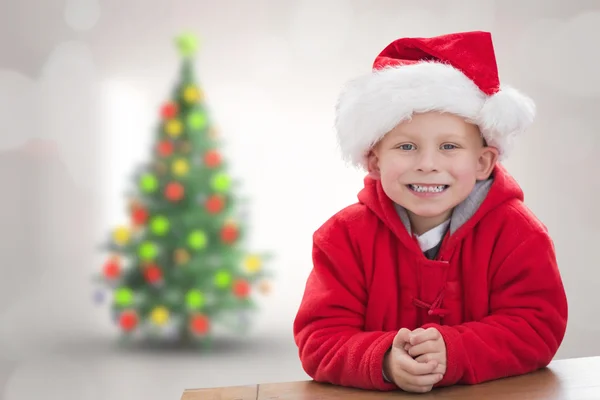 Zusammengesetzte Bild des netten Jungen mit Weihnachtsmütze — Stockfoto