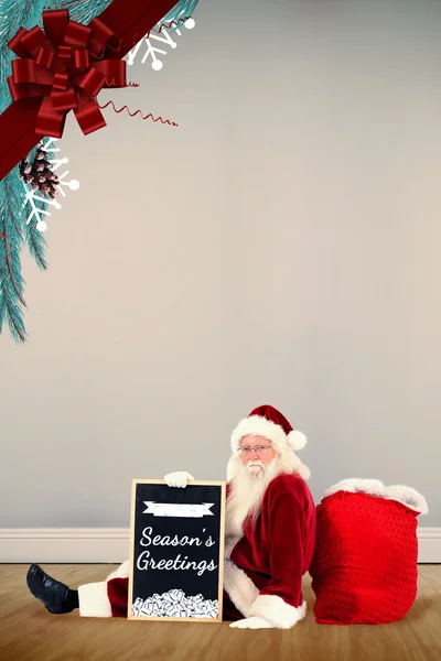 Santa sitter med styrelsen — Stockfoto