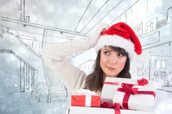 Woman scratching head and holding gifts — Stock Photo, Image