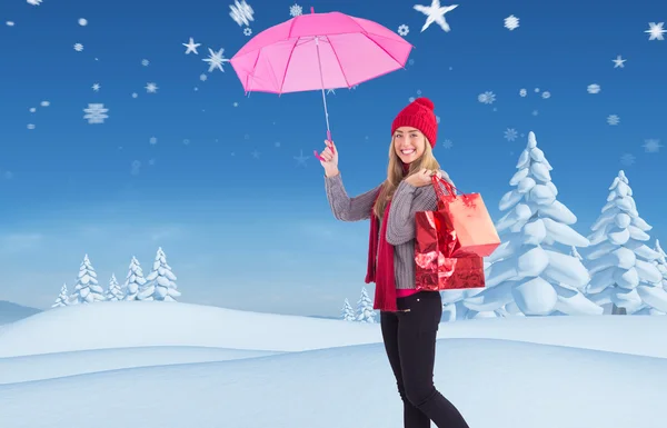 Feestelijke blonde holding paraplu en tassen — Stockfoto