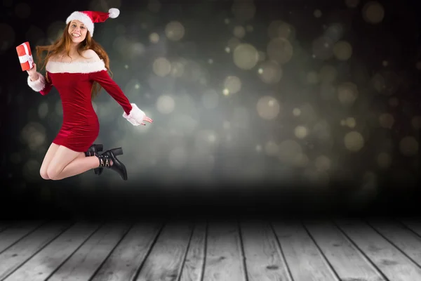 Festive redhead jumping with gift — Stock Photo, Image