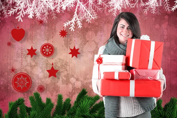 Sonriente morena sosteniendo muchos regalos — Foto de Stock