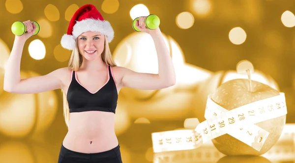 Composite image of festive fit blonde smiling at camera — Stock Photo, Image