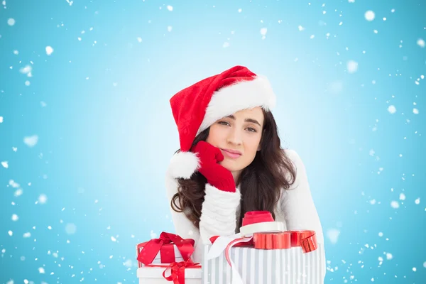 Unsure brunette in santa hat packing gifts — Stock Photo, Image