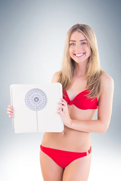 Blondin i röd bikini visar skalor — Stockfoto