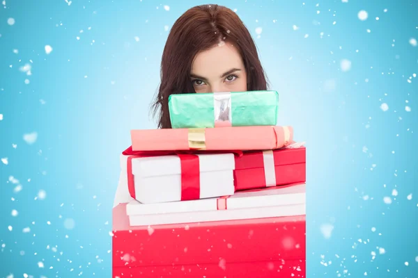 Portrait of a brunette holding pile of gifts — Stock Photo, Image