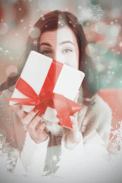 Brunette showing gift on the couch — Stock Photo, Image