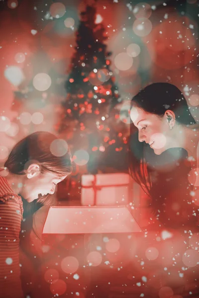 Festive madre e figlia che aprono un incandescente — Foto Stock