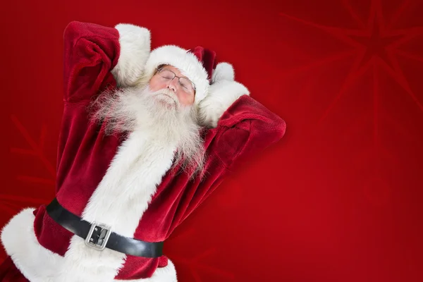 Santa slapen tegen rode achtergrond — Stockfoto