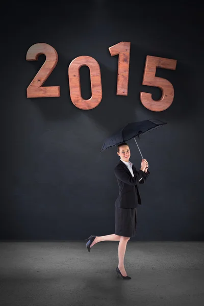 Composite image of businesswoman holding a black umbrella — Stock Photo, Image