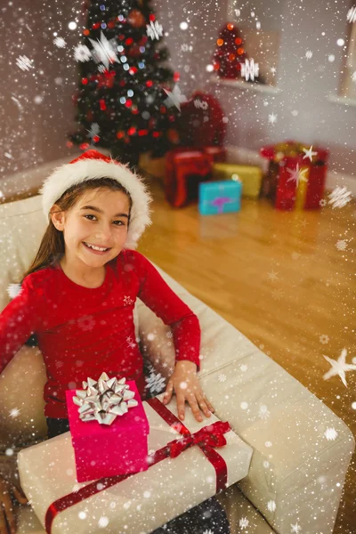 Праздничная маленькая девочка улыбается в камеру с подарками — стоковое фото